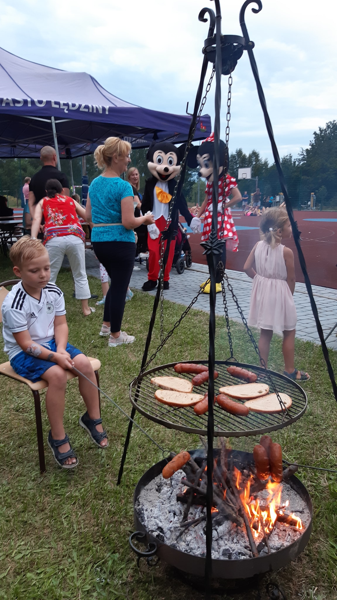 Ognisko na ruszcie palące sie kiełbaski