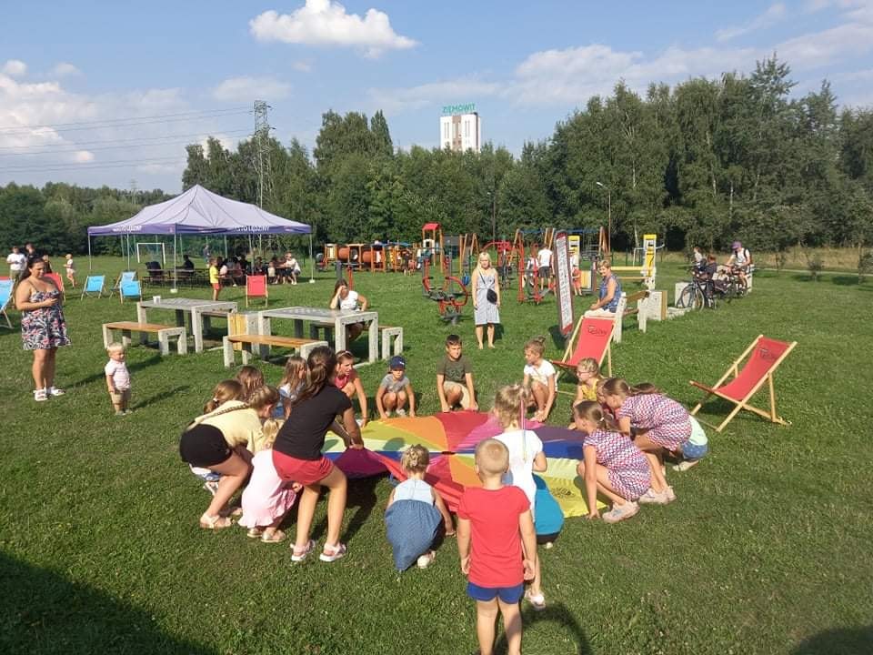 Dzieci uczestniczące w zabawie z animatorką - zabawa z chustą animacyjną 