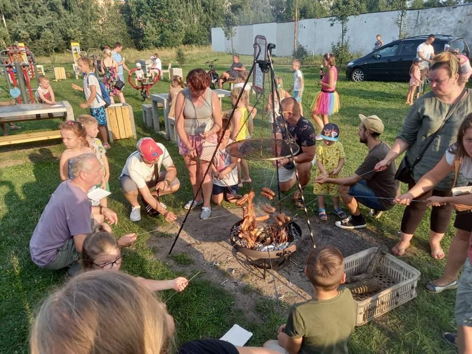 Ludzie piekący kiełbasy przy ognisku 