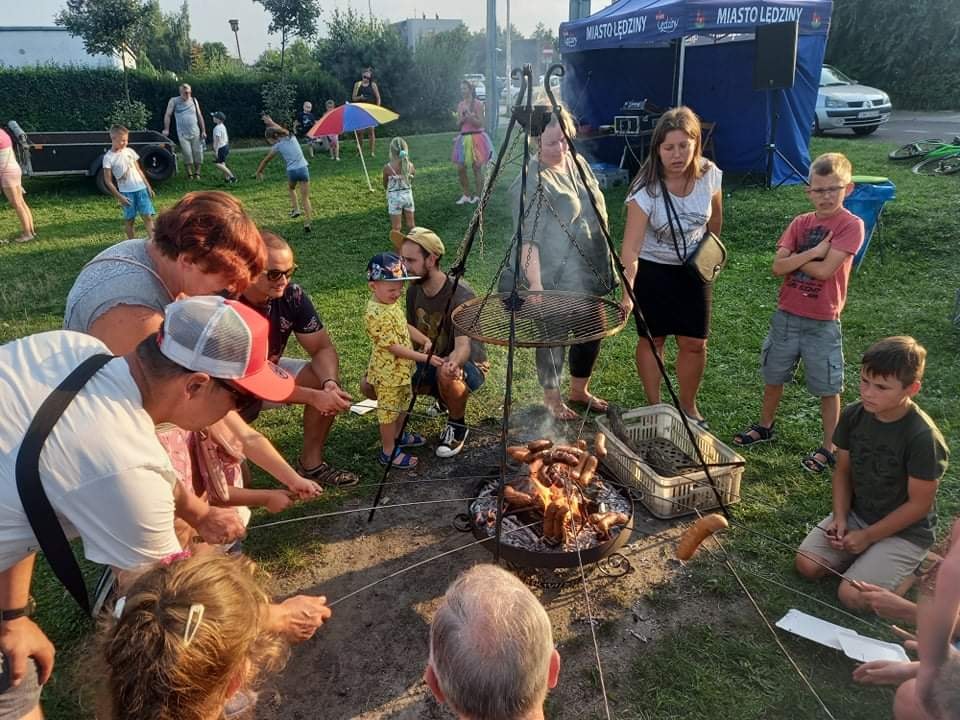 Ludzie piekący kiełbasy przy ognisku 