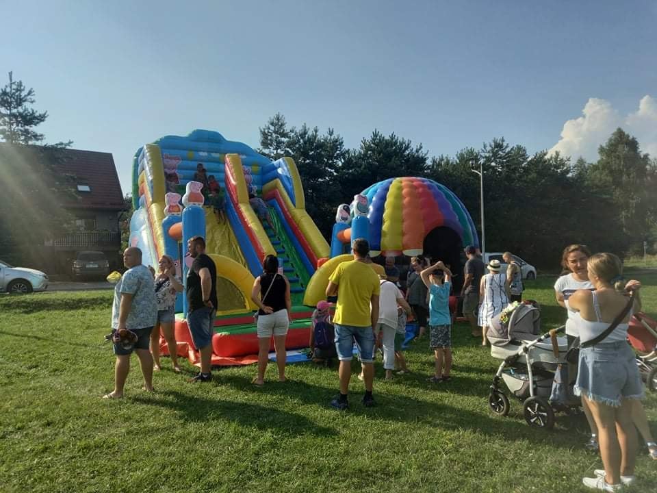 Ludzie oczekujący w kolejce do dmuchanych zjeżdżalni 