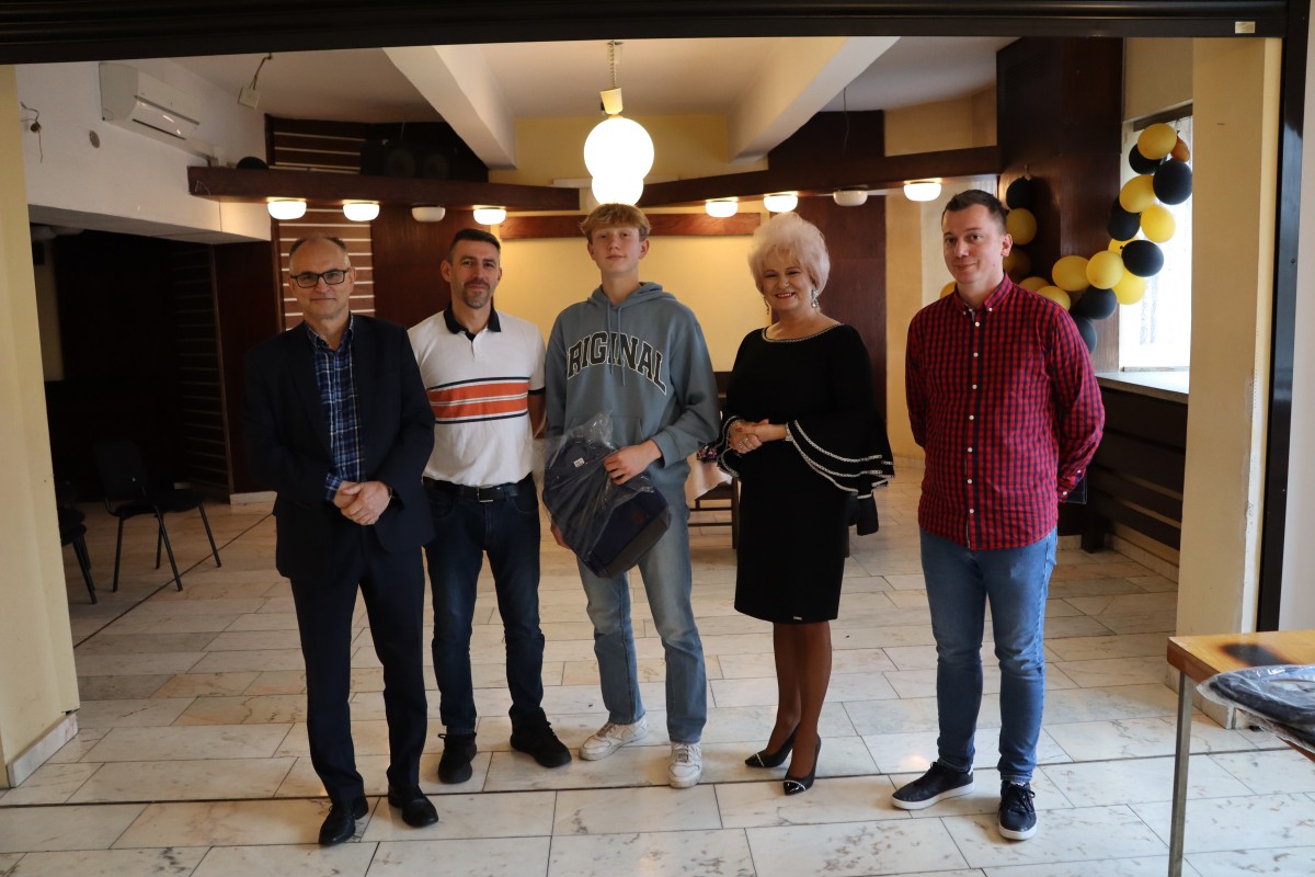 5 osób pozuje do zdjęcia z nagrodami