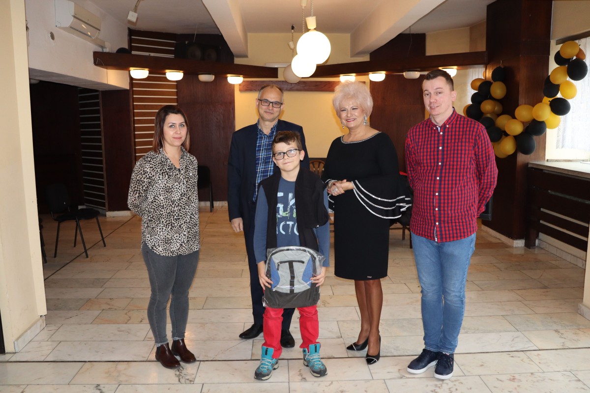 5 osób pozuje do zdjęcia z nagrodami