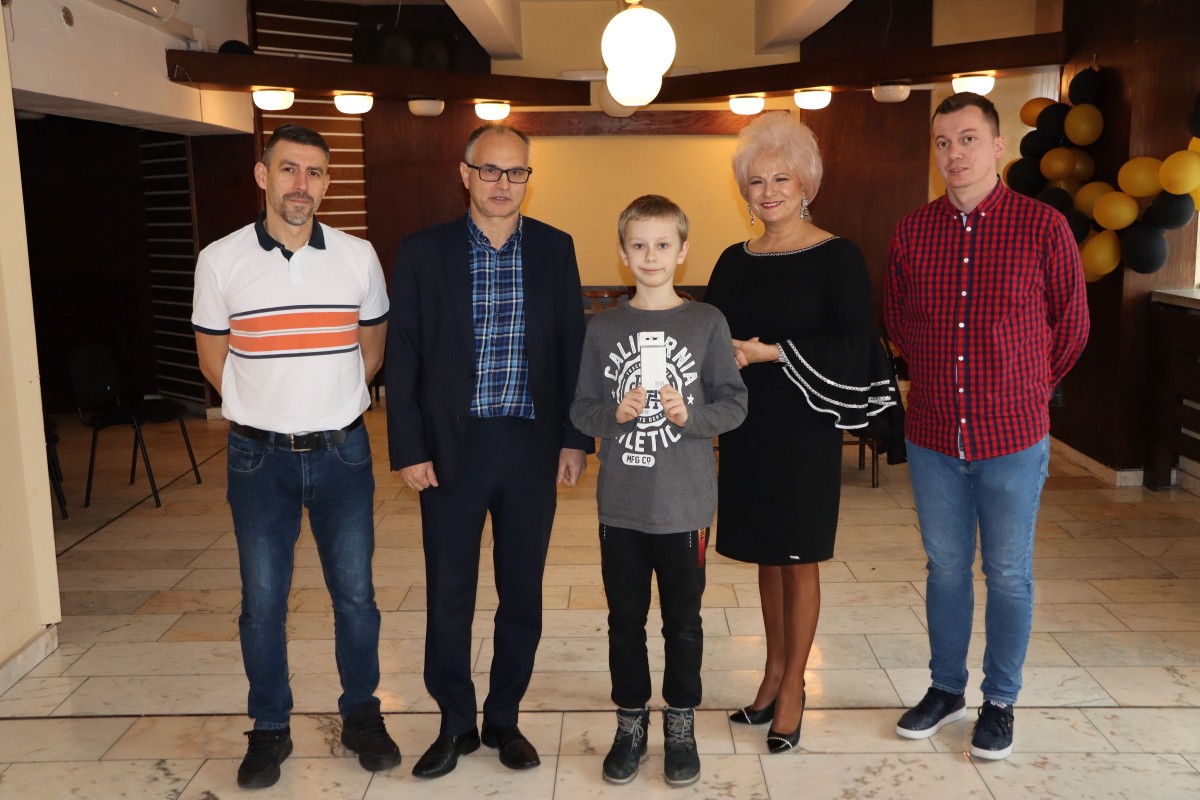 5 osób pozuje do zdjęcia z nagrodami