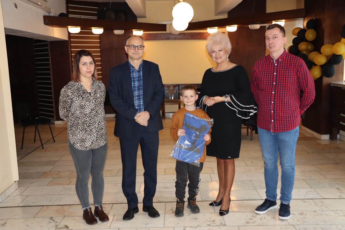 5 osób pozuje do zdjęcia z nagrodami