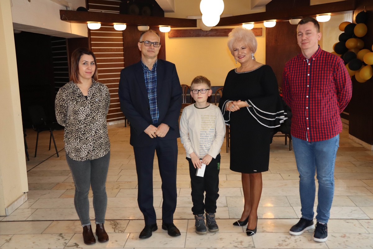 5 osób pozuje do zdjęcia z nagrodami