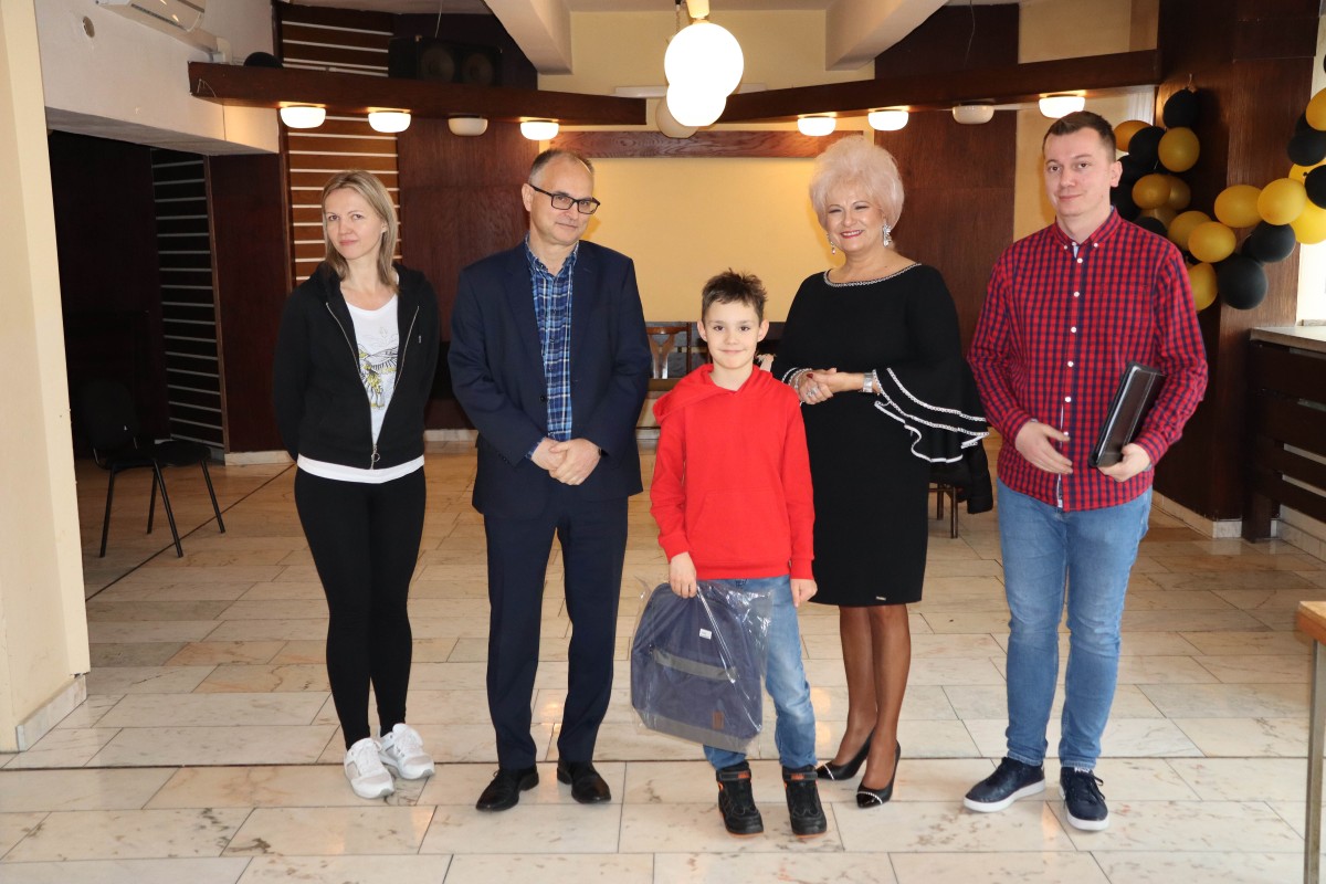 5 osób pozuje do zdjęcia z nagrodami