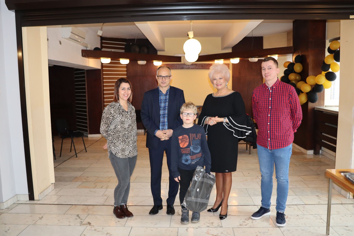 5 osób pozuje do zdjęcia z nagrodami
