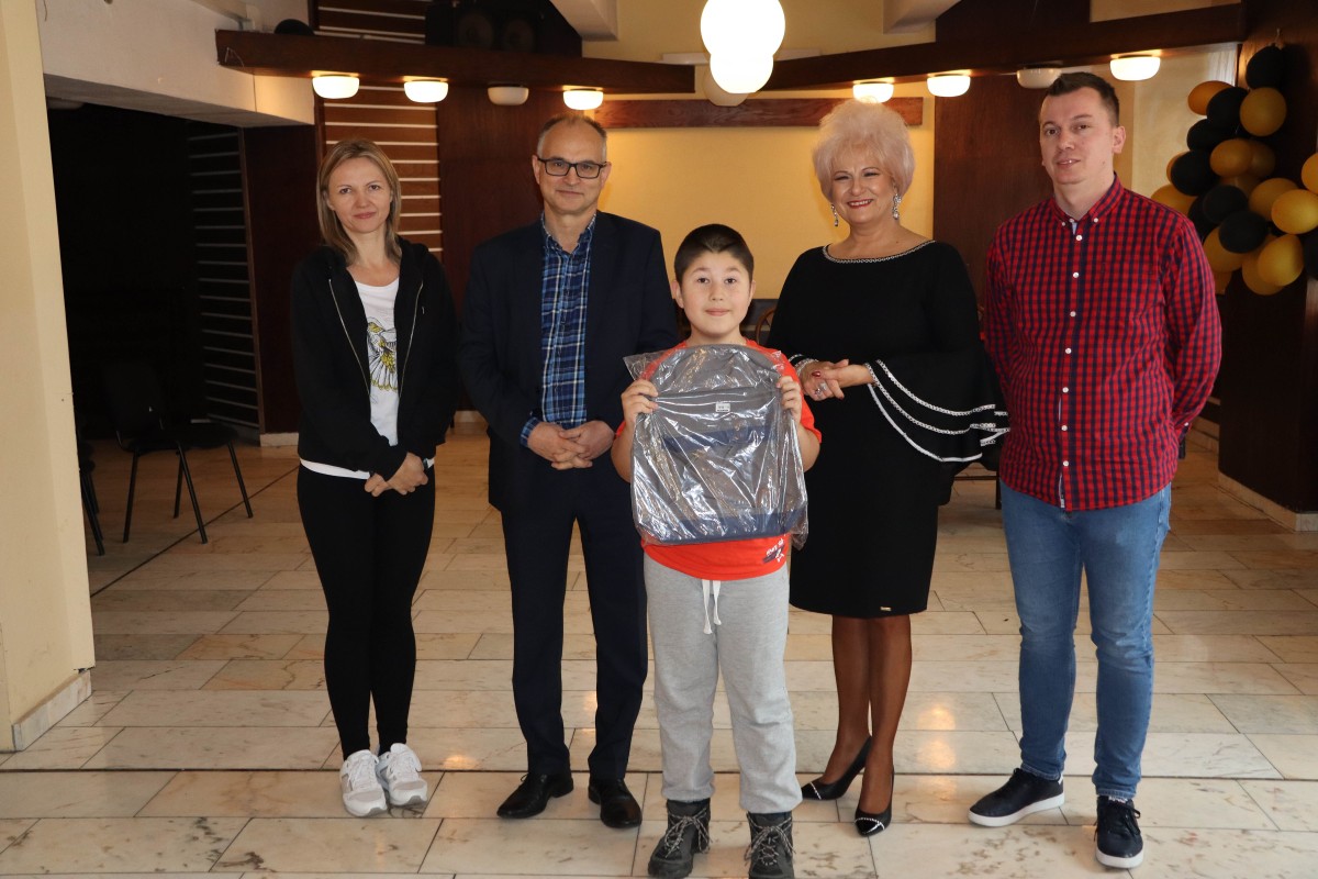 5 osób pozuje do zdjęcia z nagrodami