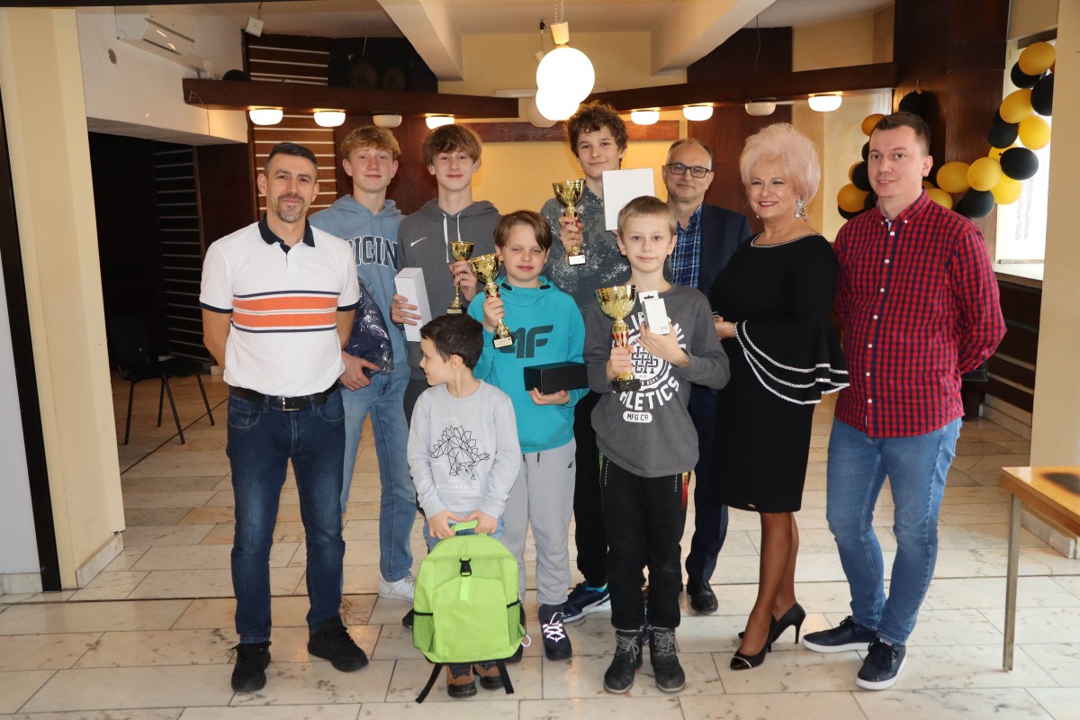10 osób pozuje do zdjęcia z nagrodami