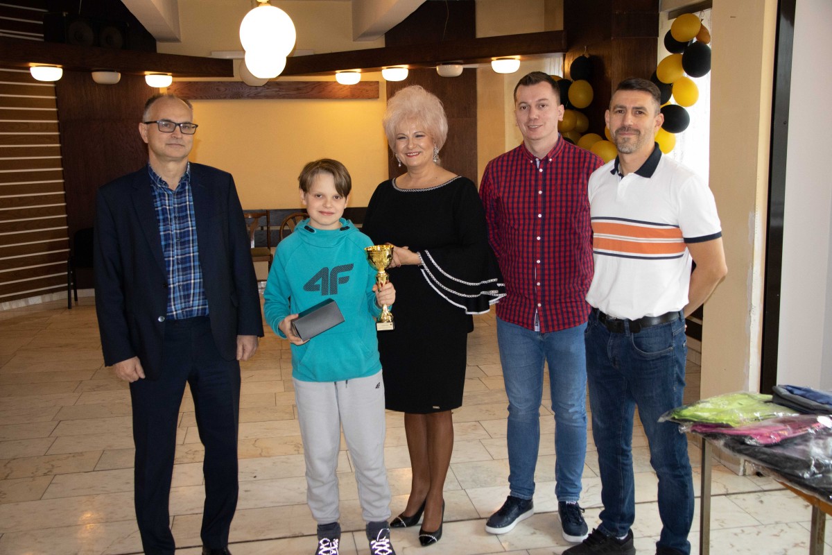 5 osób pozuje do zdjęcia z nagrodami