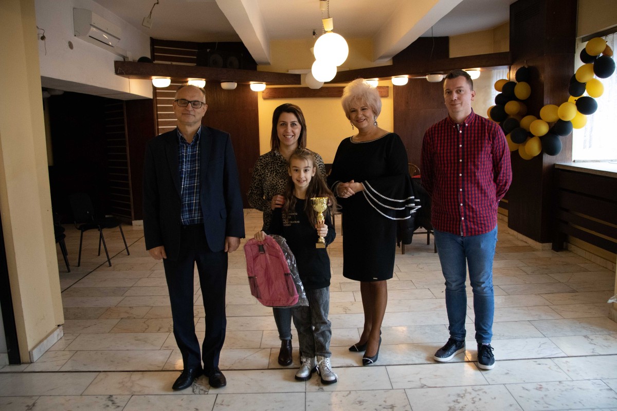 5 osób pozuje do zdjęcia z nagrodami