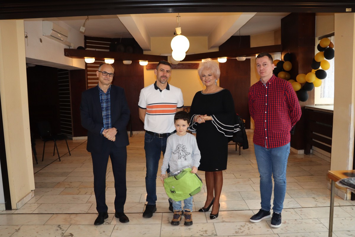 5 osób pozuje do zdjęcia z nagrodami