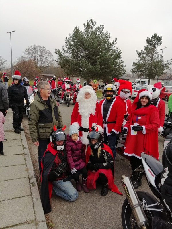 motocykliści przebrani za mikołaje pozują do zdjęcia z ludźmi