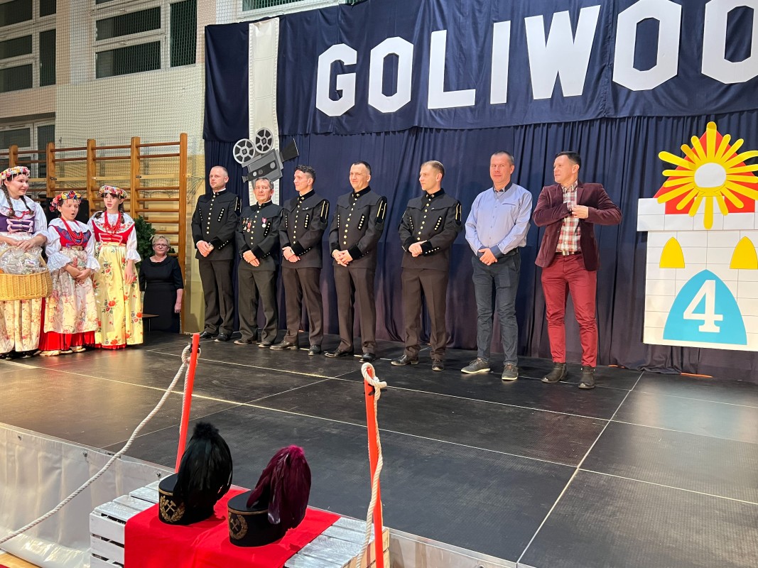 mężczyźni w strojach górniczych stoją na scenie