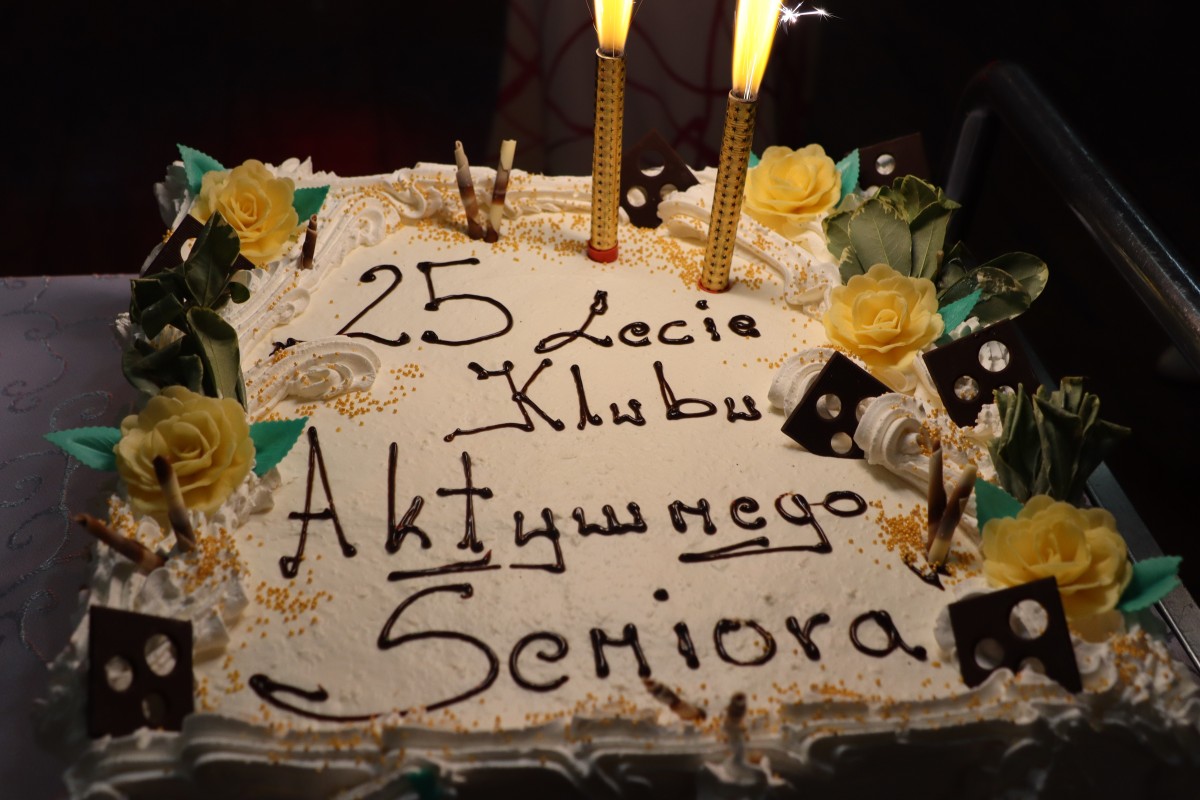 tort. na torcie zapalone dwie race. na torcie napis 25lecie klubu aktywności seniora