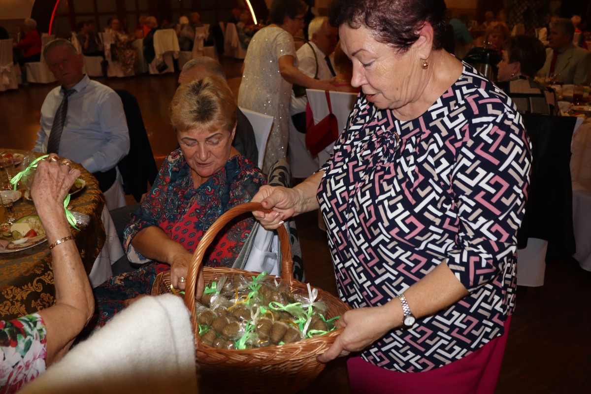 kobieta z koszykiem wręcza upominki gościom
