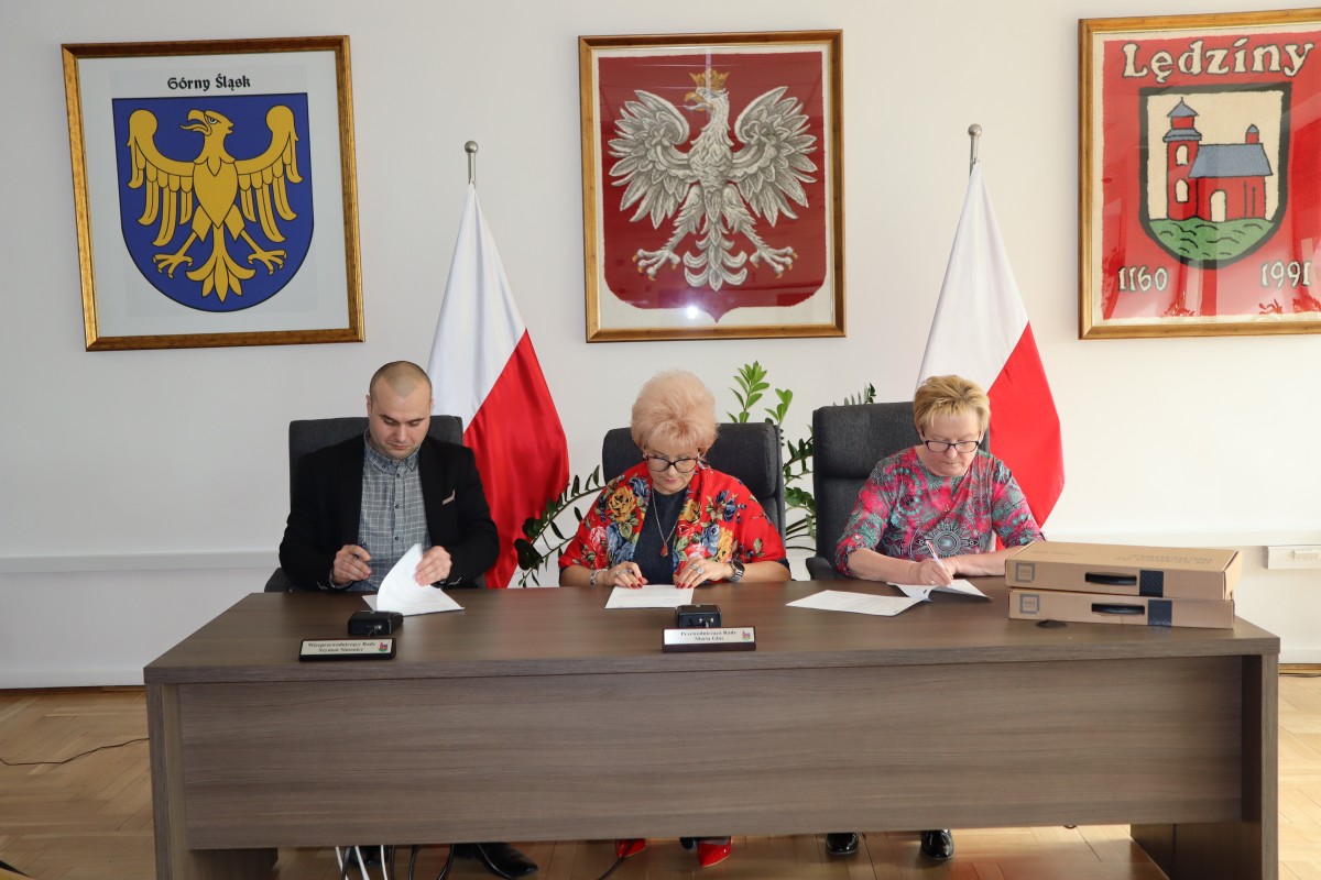Na zdjęciu trzy osoby podczas podpisania dokumentów