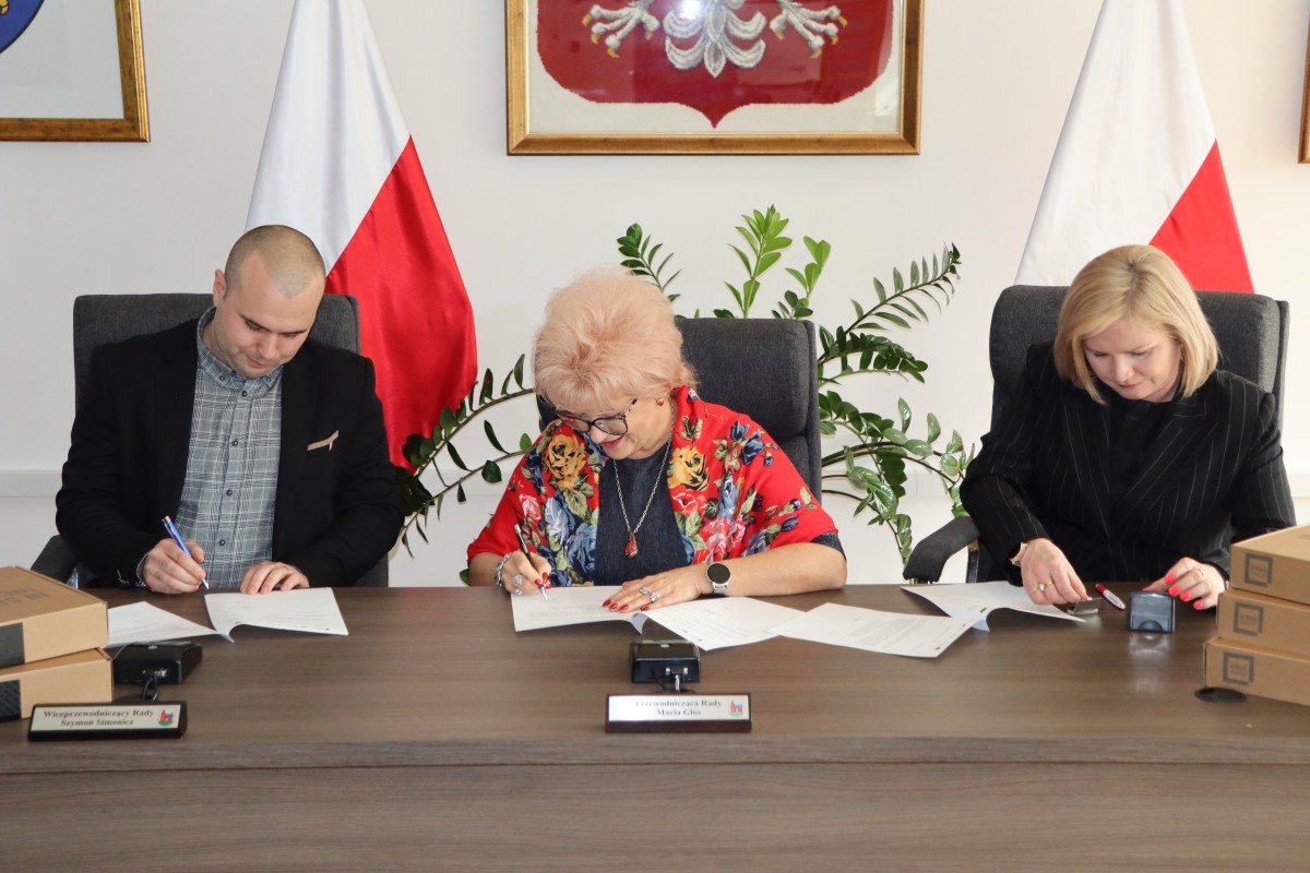 Na zdjęciu trzy osoby podczas podpisania dokumentów