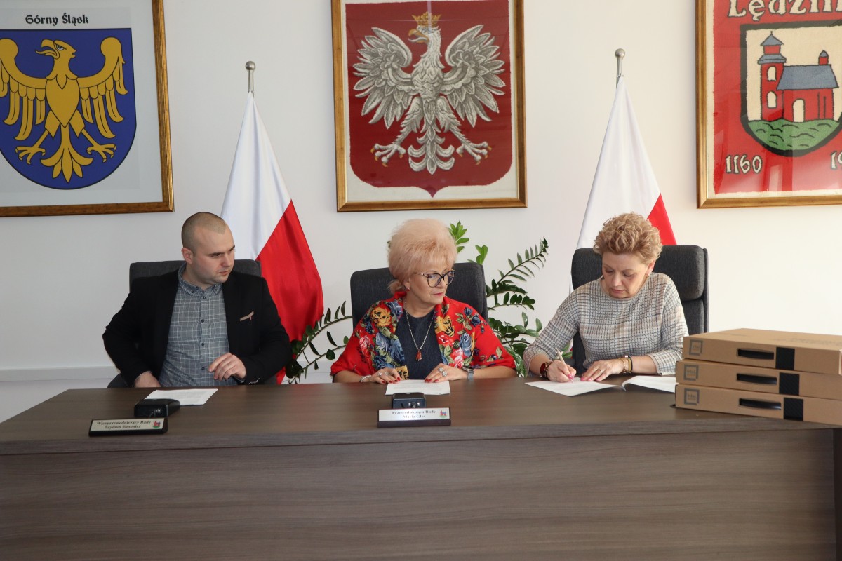 Na zdjęciu trzy osoby podczas podpisania dokumentów