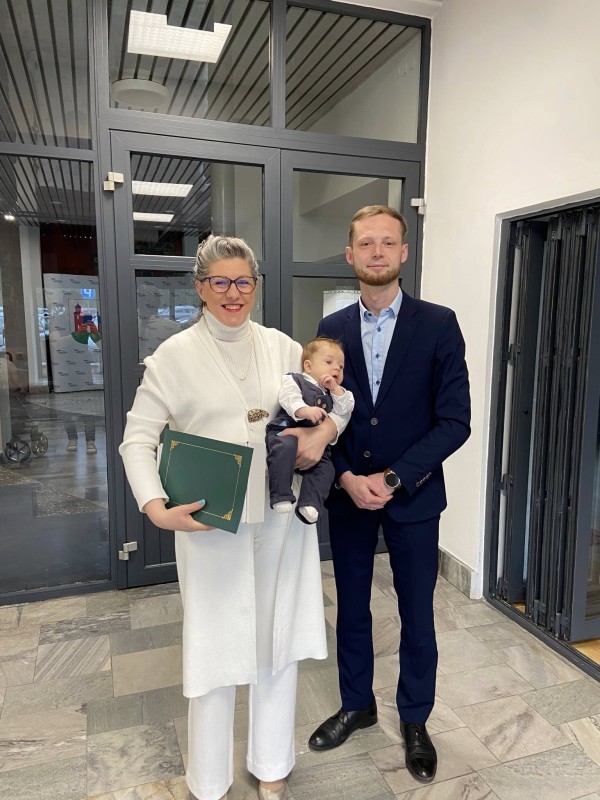 Zdjęcie przedstawia rodziców z dziećmi. Obok stoi burmistrz miasta