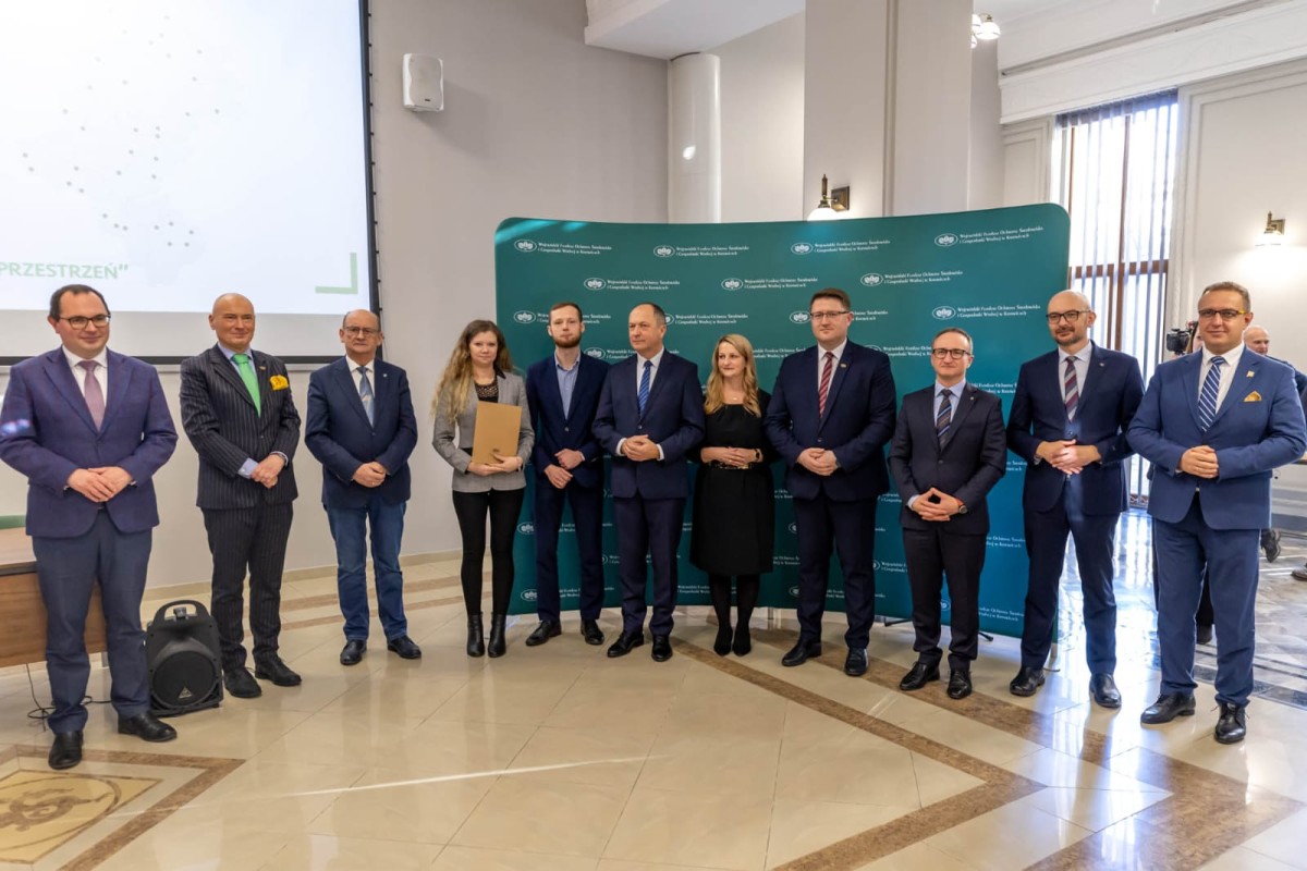 Grupa osób w garniturach i krawatach stojąca razem, prezentująca profesjonalny wizerunek.